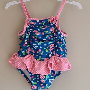 Blue one piece swimsuit with pink polka dot ruffle and trim